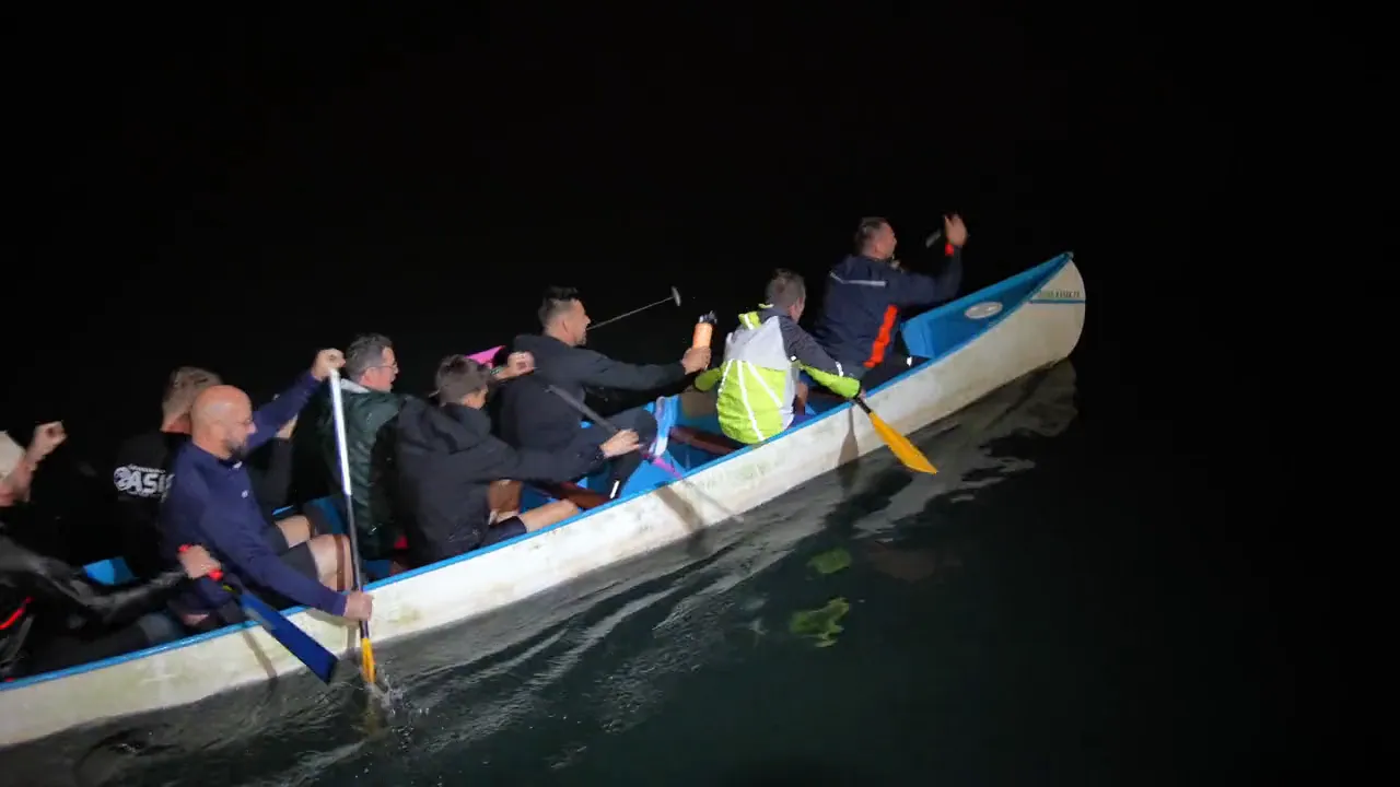 Un équipage pagaie de nuit dans un grand canoë, pour les 60 ans du club